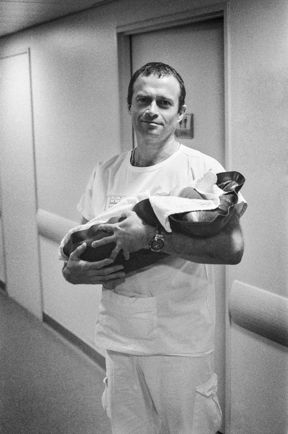 Un médecin tient un nouveau né dans ses bras au retour à l'hôpital 