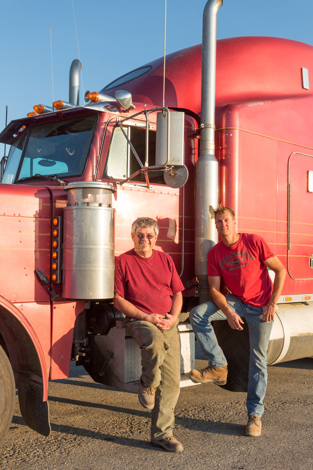 Deux camionneurs posent pour la photo devant un camion