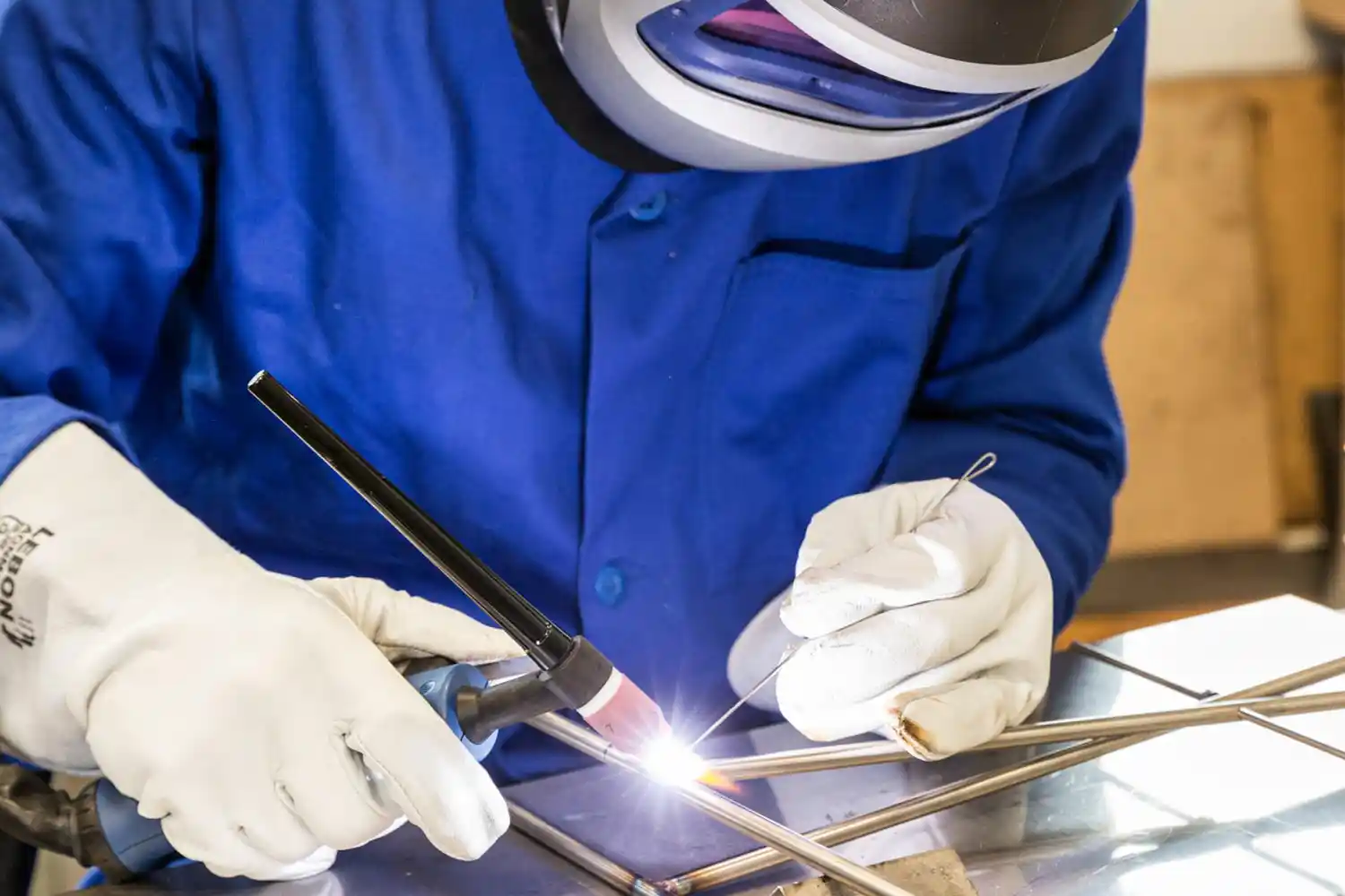 Un technicien réalise de la soudure sur métaux avec un chalumeaux. Photographie de reportage industriel